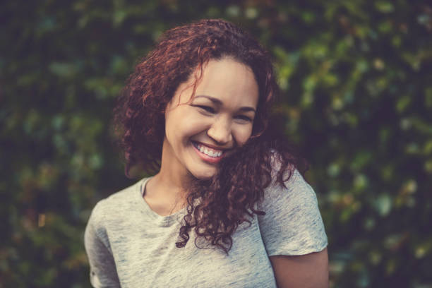 istock Smiling young woman standing against plants 915113792
