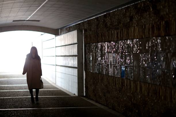 istock Woman walking through the dark tunnel 915113794