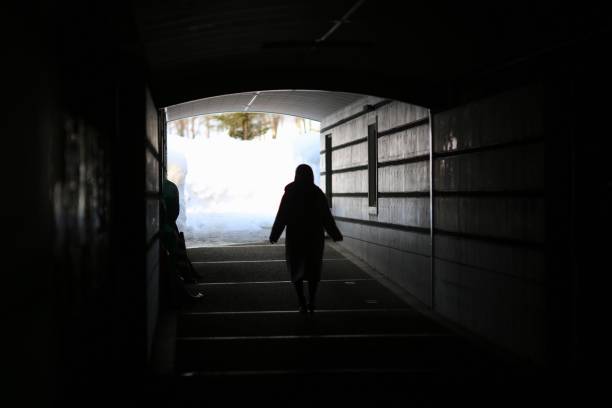 istock Woman walking through the dark tunnel 915113816