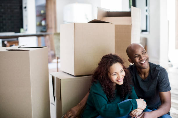 istock Couple with cardboard boxes sitting in new house 915113842