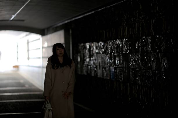 istock Woman walking through the dark tunnel 915113854