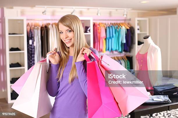 Молодая Женщина В Магазин Одежды Holding Shopping Bags — стоковые фотографии и другие картинки Весёлый