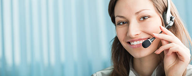 Happy support phone operator in headset at workplace stock photo