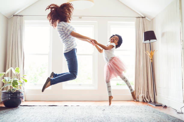 istock Mother and daughter jumping while doing ballet 915117098