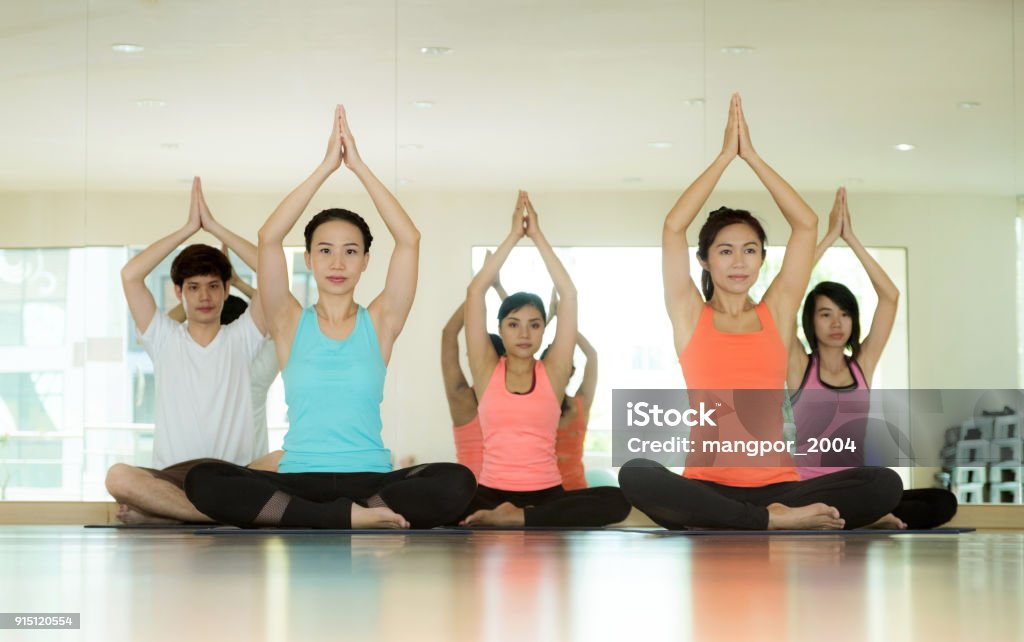 Group of asian women and man practicing yoga, fitness stretching flexibility pose, working out, healthy lifestyle, wellness, well being Adult Stock Photo