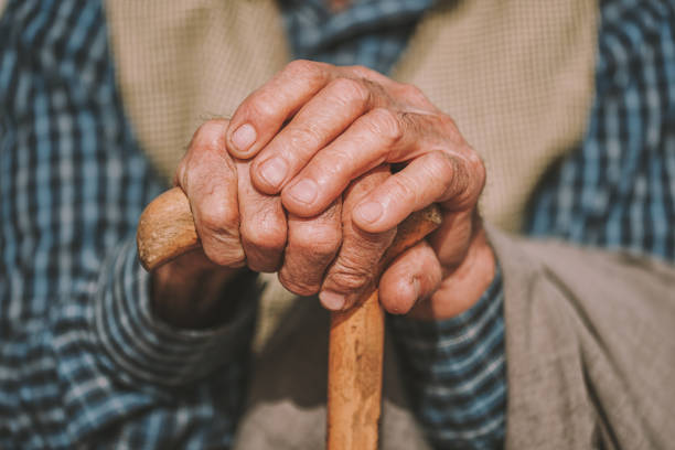 istock hand of a senior man holding a cane 915124474