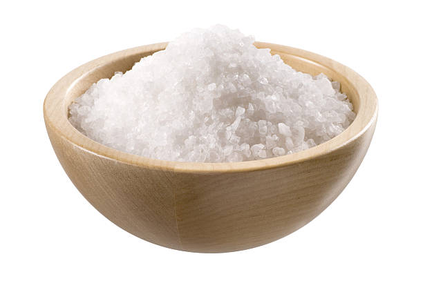 Coarse sea salt in a small wooden bowl on a white background Sea salt in a  wooden bowl  isolated on white bath salt photos stock pictures, royalty-free photos & images