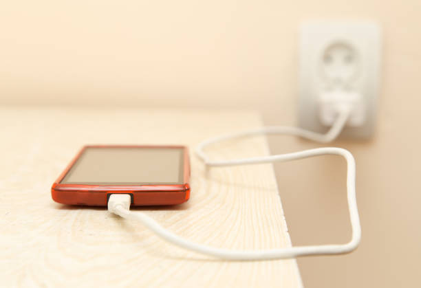 istock cell phone is being charged from the electrical outlet 915131950