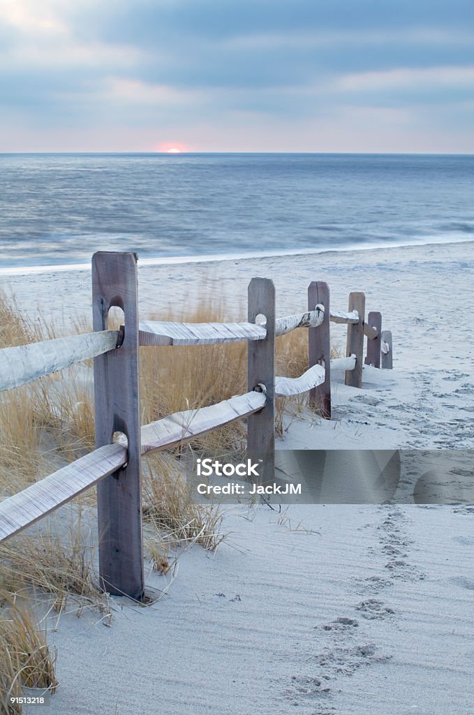 Wooden railing next to sandy path leading to beach Path to the beach with a fence at Cape May Point,NJ. Beach Stock Photo