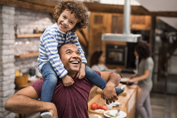 istock Happy black father having fun with his small son while carrying him on shoulders. 915141180