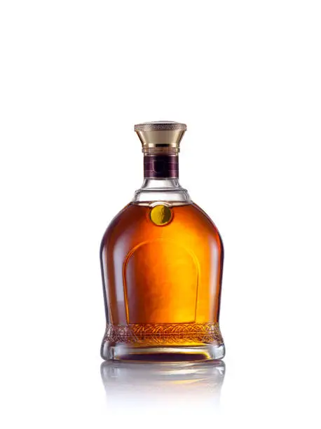 close up view of whiskey bottle on white back.
