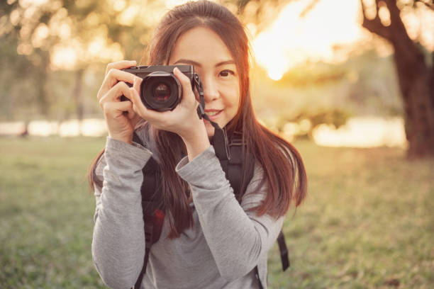istock traveler hold mirrorless camera in his hands with blurred nature background, copy space 915143892