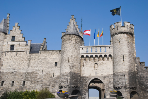The entrance of the medieval castle Het Steen (The Stone), in Antwerp, Belgium, showing the flags of Antwerp, EU and, Flanders and Belgium