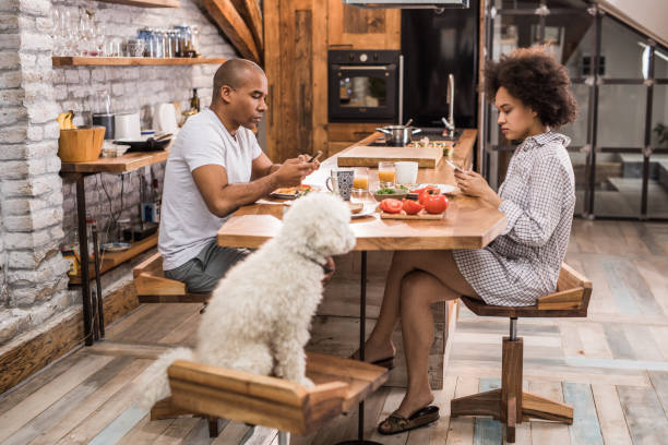 istock African American couple ignoring each other while using cell phones during breakfast. 915146414