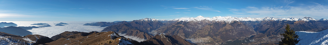 Drone aerial view to the Po plain, Seriana valley and Orobie Alps. The fog covers all the villages and the Padana plain