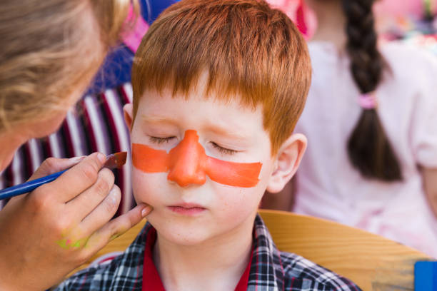 istock Child boy face painting, making tiger eyes process 915147712