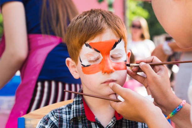 istock Child boy face painting, making tiger eyes process 915147744