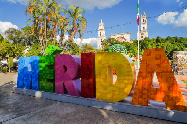 kolorowy znak merida z meksykańską flagą i ulicą katedry. park przed znakiem merida na plaza grande w merida, meksyk - latin america travel destinations yucatan mexico zdjęcia i obrazy z banku zdjęć