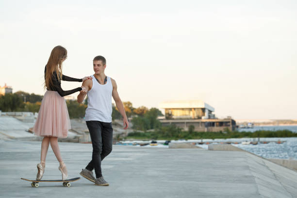 istock Ballerina on a skateboard. The guy helps 915152176