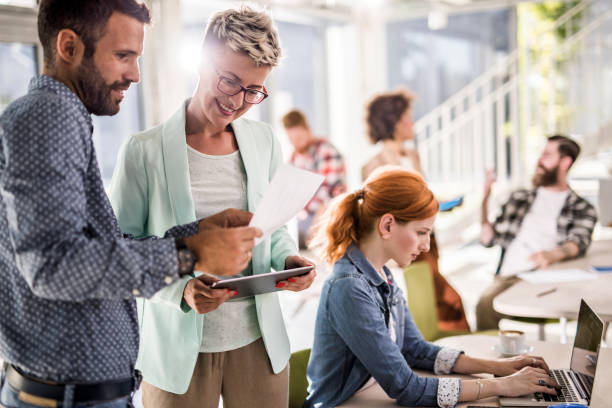 istock Happy colleagues cooperating while working on business reports at corporate office. 915157584