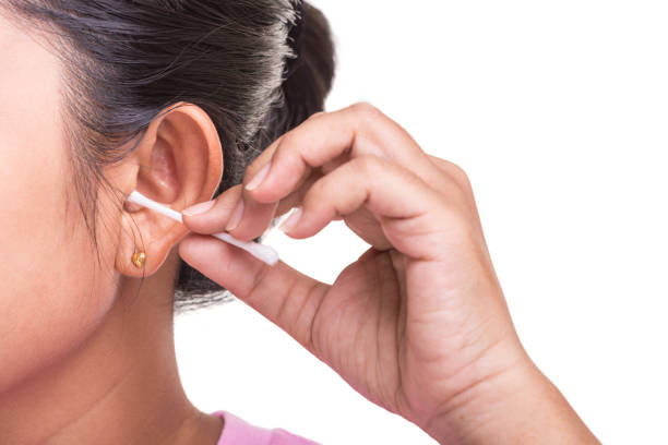 istock Woman cleaning her ear by using cotton bud stick isolated on white background 915157786