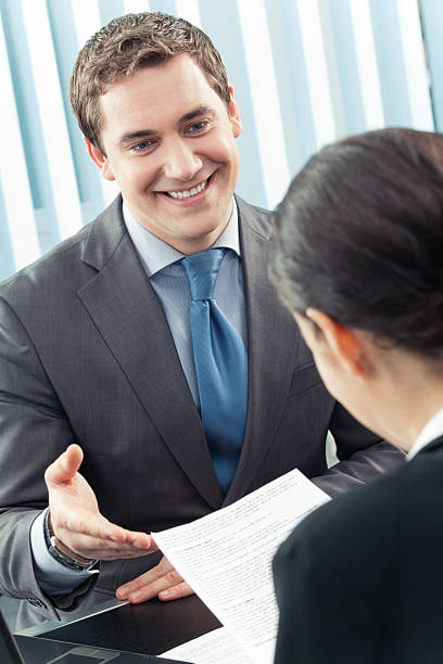 istock Two businesspeople, or businessman and client, with document at office 91515985