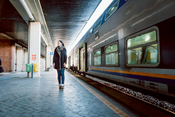 istock Young woman walking on train station platform 915161308