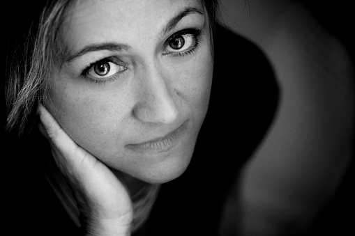 nice woman looking at camera with open bright eyes. Beautiful portrait for a 40 years old female. Fine art black and white