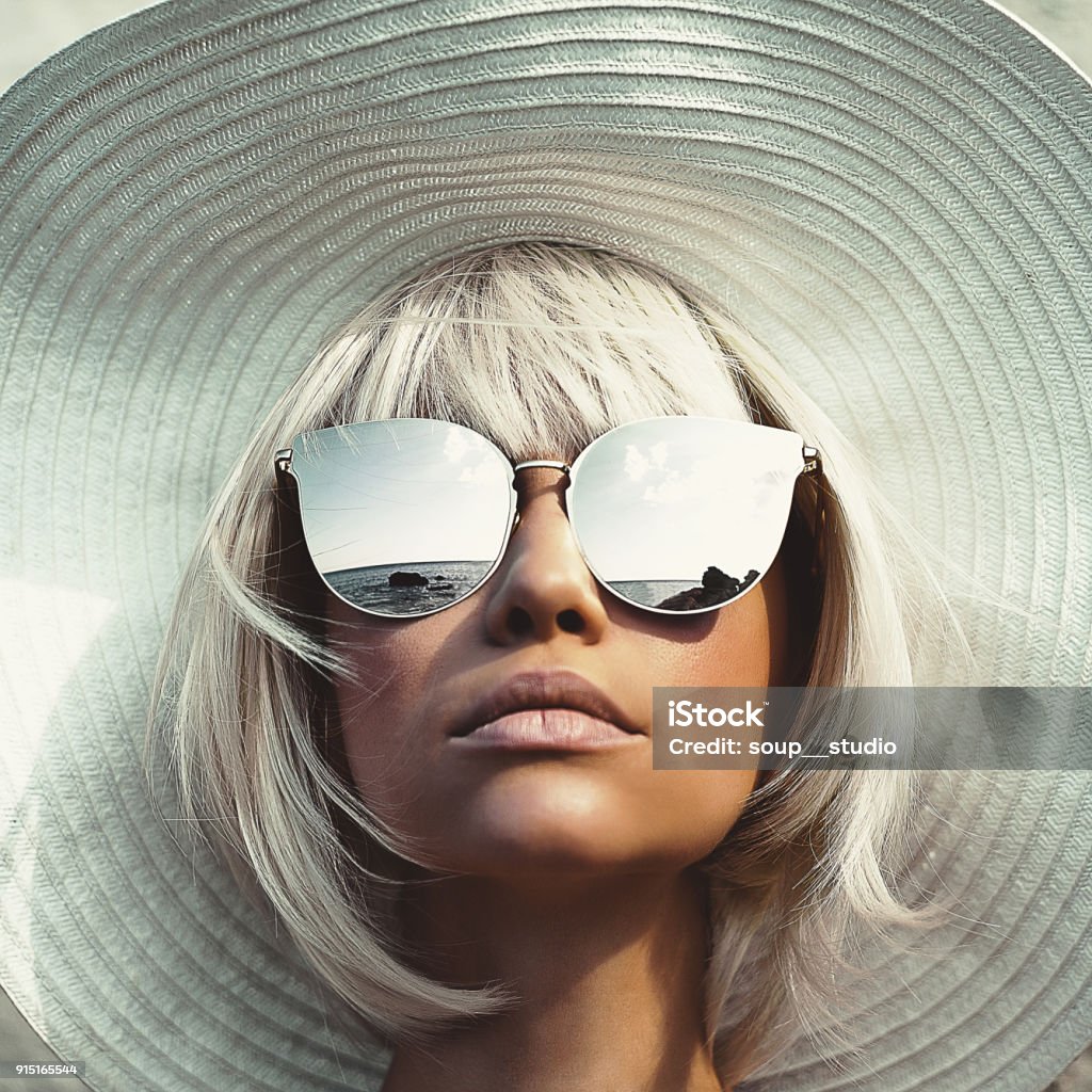 Outdoor photo of young lady in hat and sunglasses Outdoor fashion photo of young beautiful lady in hat and sunglasses. Summer Beach travel. Summer vibes Fashion Stock Photo