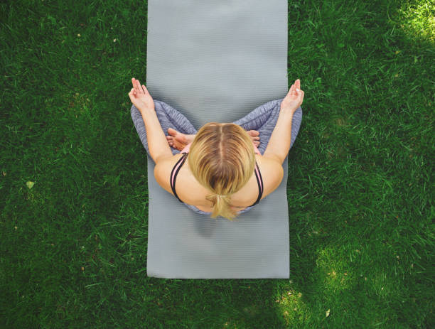 istock Young woman outdoors, relax meditation pose 915177532