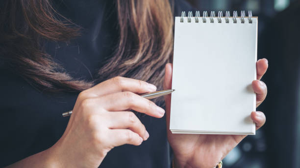 istock woman holding and showing a blank notebook 915184528