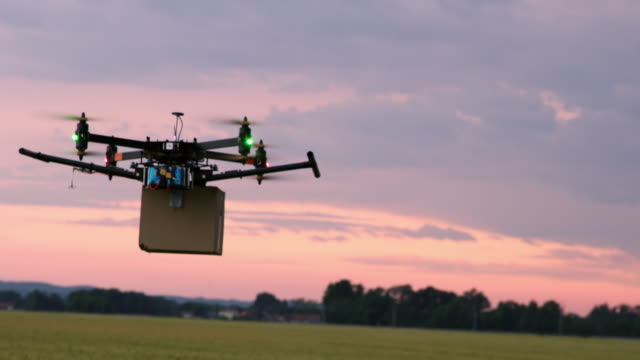 LS Drone flying over fields with a package at dusk