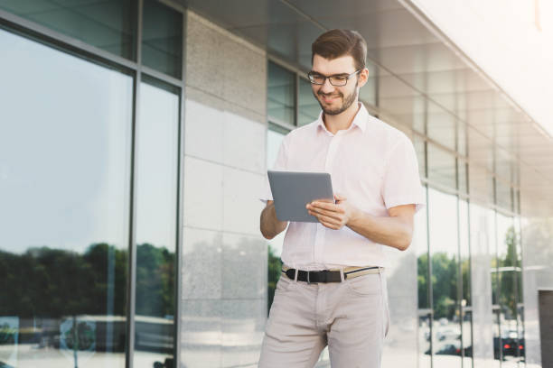 istock Smiling businessman working with tablet outdoors 915198794