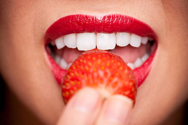 Plano aproximado de mulher Sexy boca e lábios a comer morango - fotografia de stock