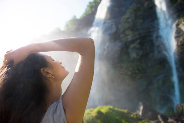 frau vor wasserfälle - waterfall water nature zen like stock-fotos und bilder