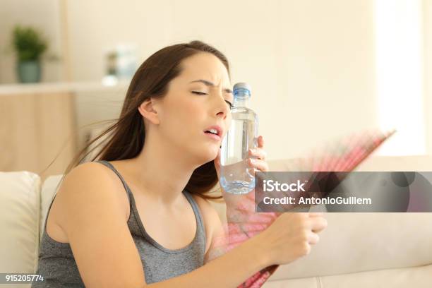 Girl Suffering A Heatstroke Refreshing With A Fan Stock Photo - Download Image Now - Heat - Temperature, Hyperthermia, Sweat