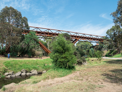 Melbourne, Australia - January 26, 2018: elevated walkway crossing Gardiners Creek connecting two parts of the Deakin University Burwood campus. Construction of the footbridge was controversial.