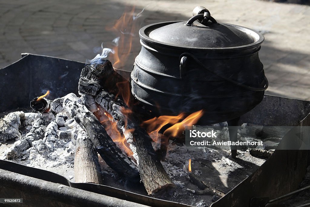 De culinária em uma fogueira com uma panela de ferro - Foto de stock de Comida royalty-free