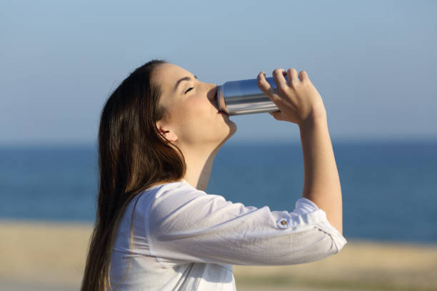 istock Woman refreshing drinking soda on the beach 915213600