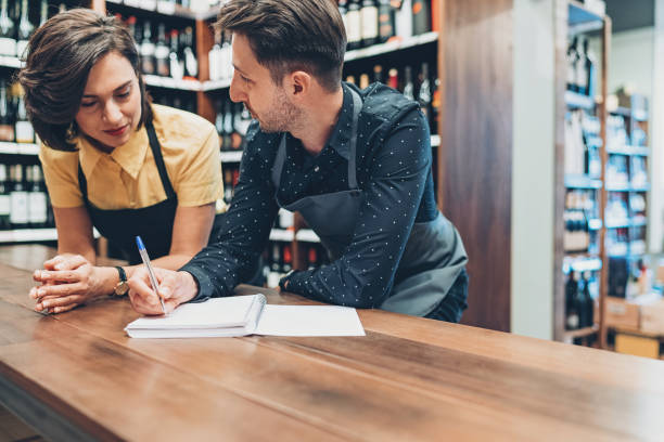 Couple of winery owners talking and writing in a textbook