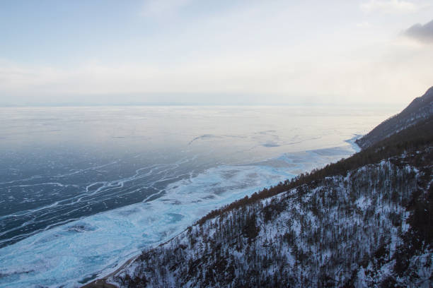 istock hill slope with trees against ice water surface,russia, lake baikal 915217914
