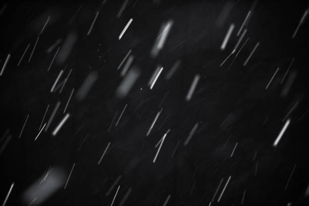 istock Falling down the snow on black background. Texture for overlay. Snowy weather, Blizzard and storm. The bokeh effect. Glowing snowflakes. 915218686