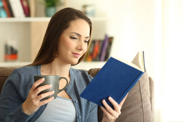 istock Relaxed lady reading a book and holding a mug 915219078