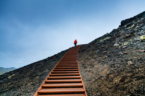 Man Walking on Stairs on a Mountain Against Blue Sky