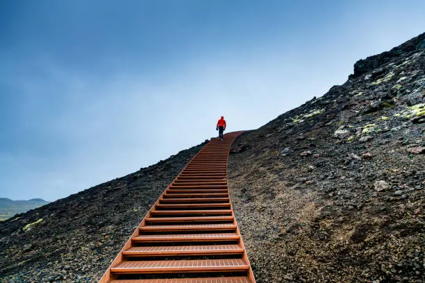 Photo of Man Walking on Stairs on a Mountain Against Blue Sky