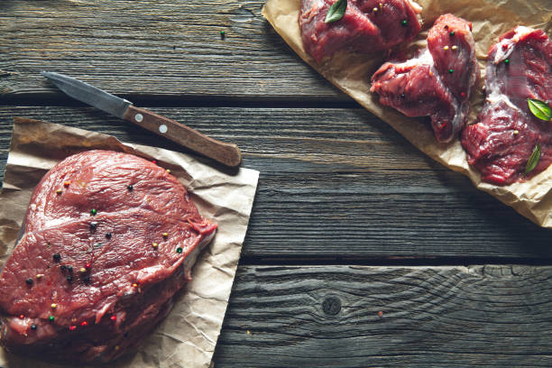 istock Fresh meat on a wooden background with spices. 915222550