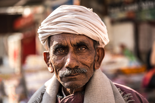 Pushkar, Rajasthan, India - November 2022: Pushkar fair, Portrait of an rajasthani old male with in white traditional dress and turban at pushkar fair ground.