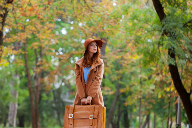 istock Young redhead woman with suitcase 915237306