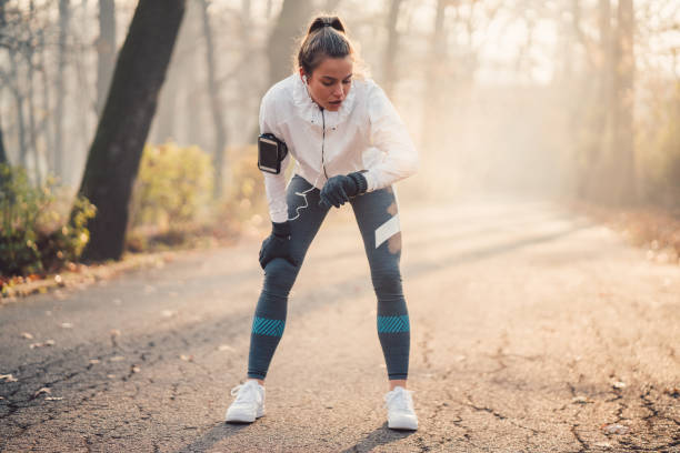 спортсменка с помощью фитнес-трекера - jogging running taking pulse women стоковые фото и изображения