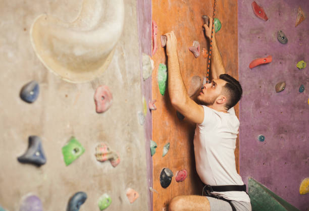 istock Young man climbing artificial rock wall at gym 915242124